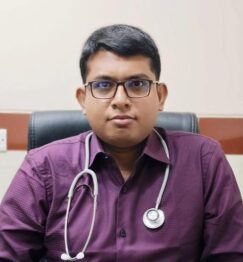 Dr. Sanjoy Kumar Paul seated at his chamber wearing a stethoscope and maroon shirt, Gastroenterologist in Rajshahi