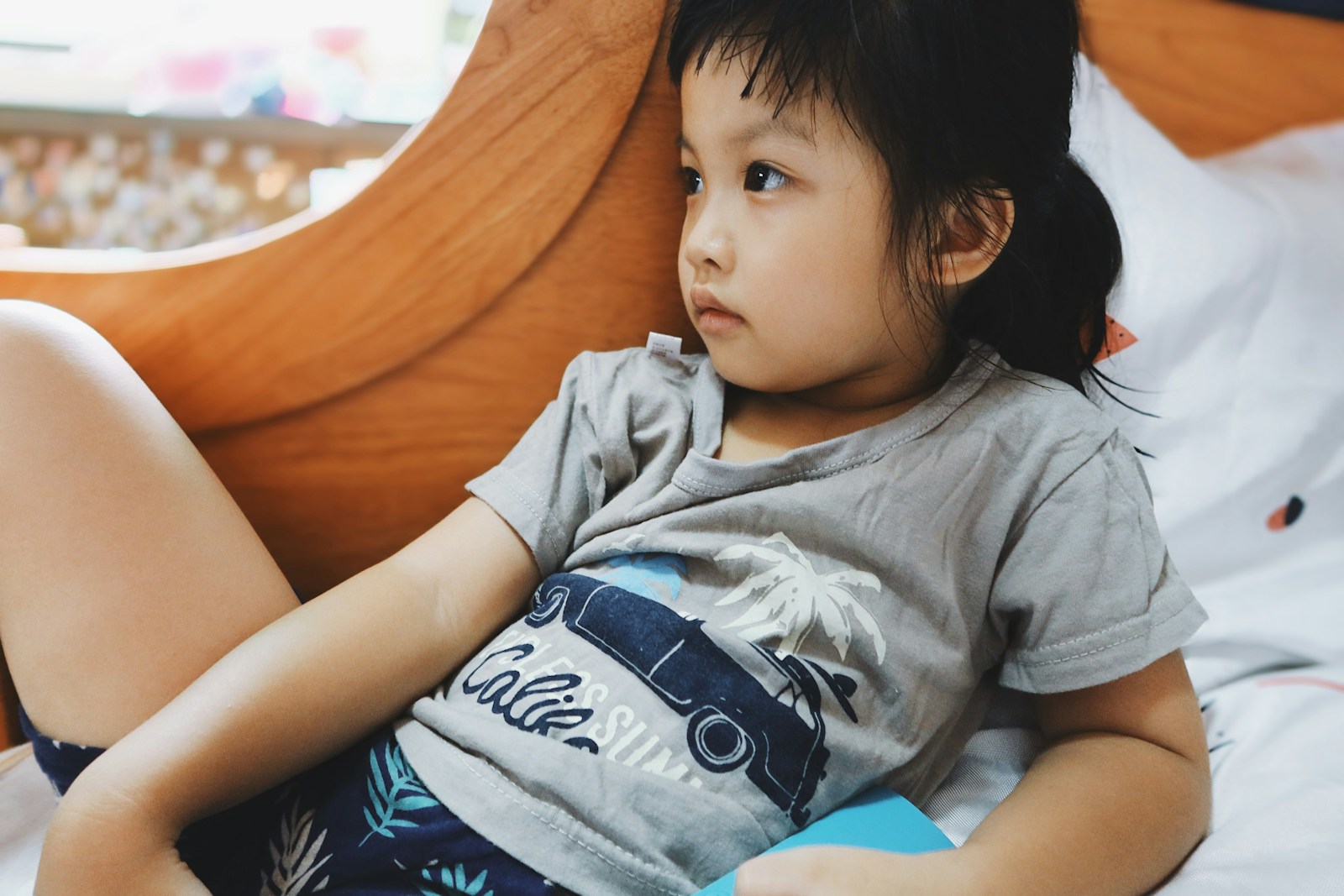 Children in gray crew neck t-shirt lying on bed