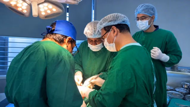 Multidisciplinary surgical team collaborating during an oral cancer operation